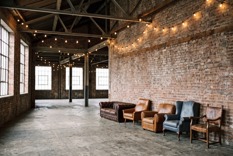 A warehouse hall set for a gathering with festoon lights