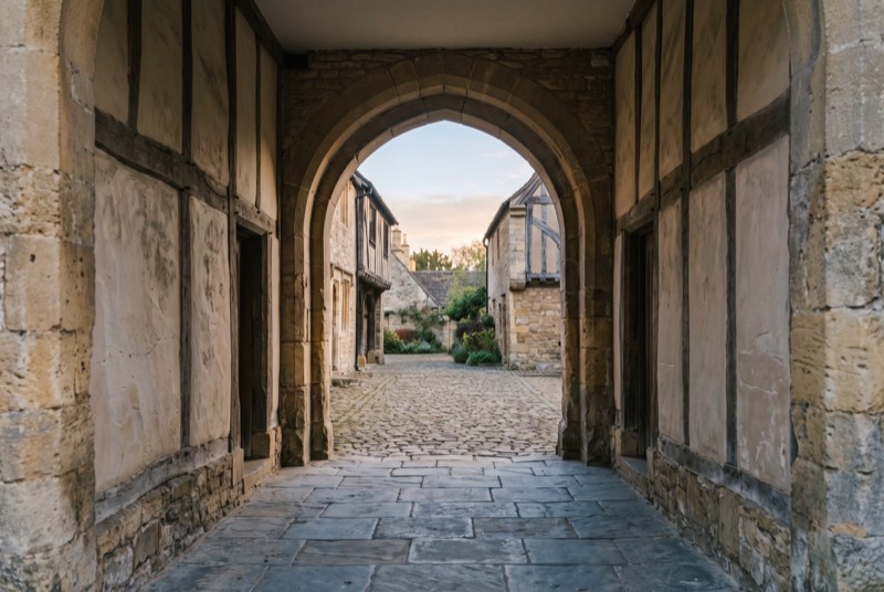 A gatehouse arch opening onto a courtyard at dawn