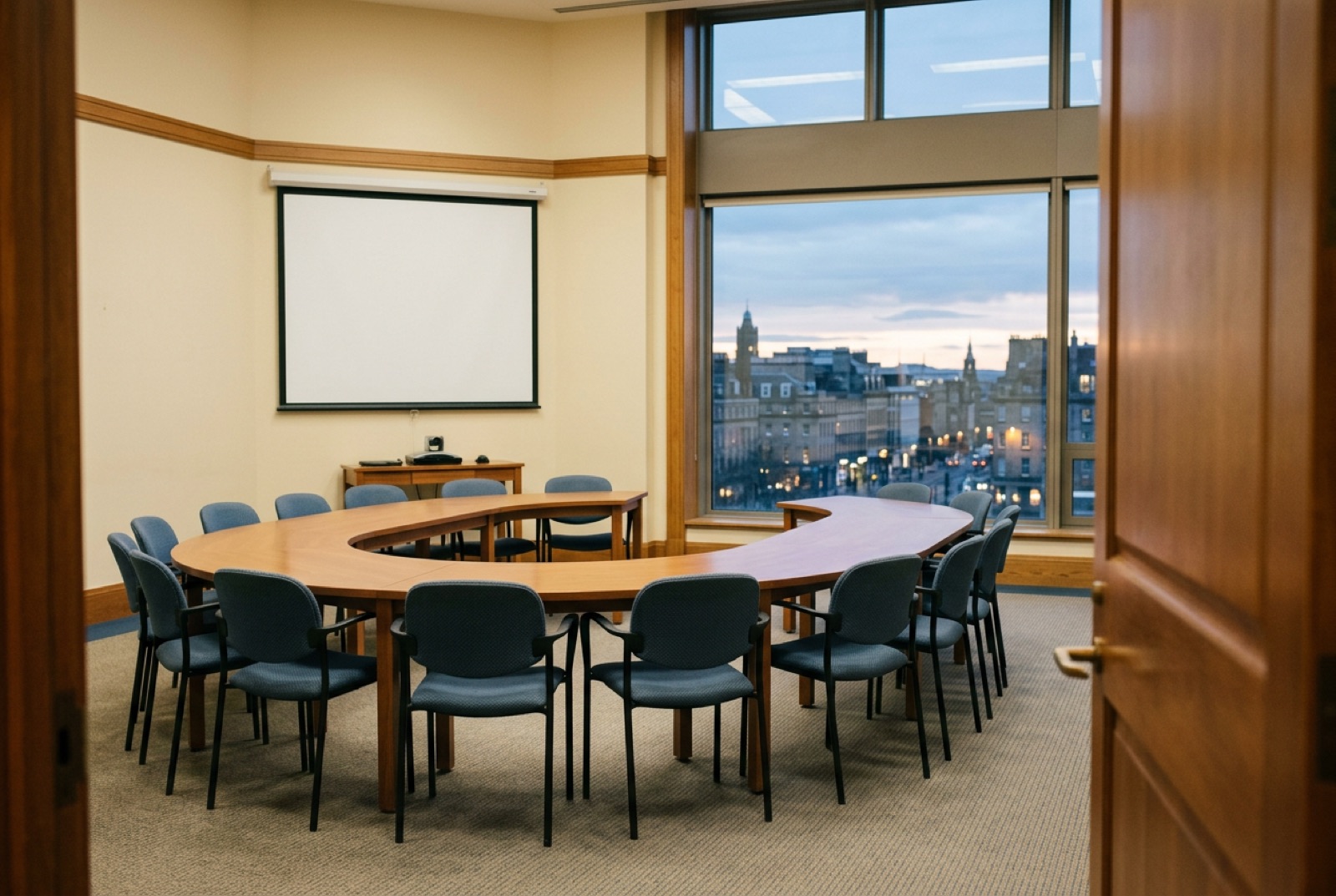 A seminar room with a horseshoe table and a projector's white square