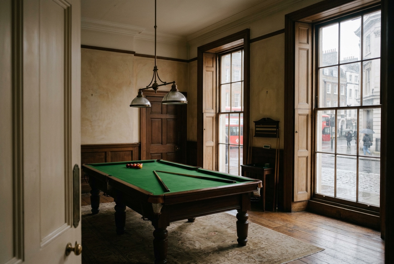 A billiard room with green baize and tall shuttered windows