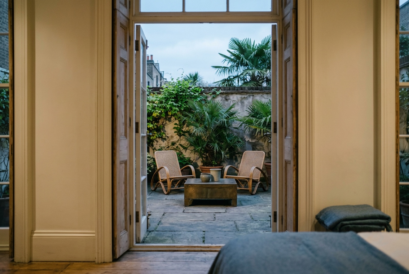 A courtyard garden of a townhouse club with cane chairs