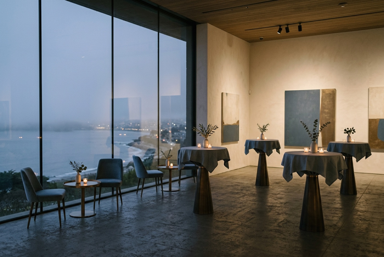 A gallery space with cocktail tables and low light before guests arrive