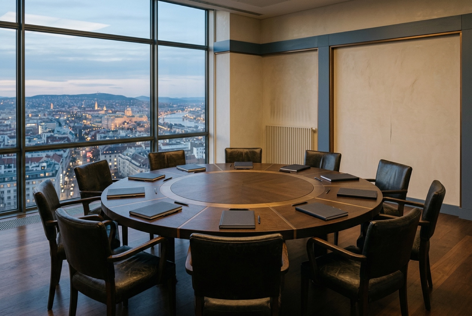 A round forum table with twelve leather chairs in a top-floor meeting room