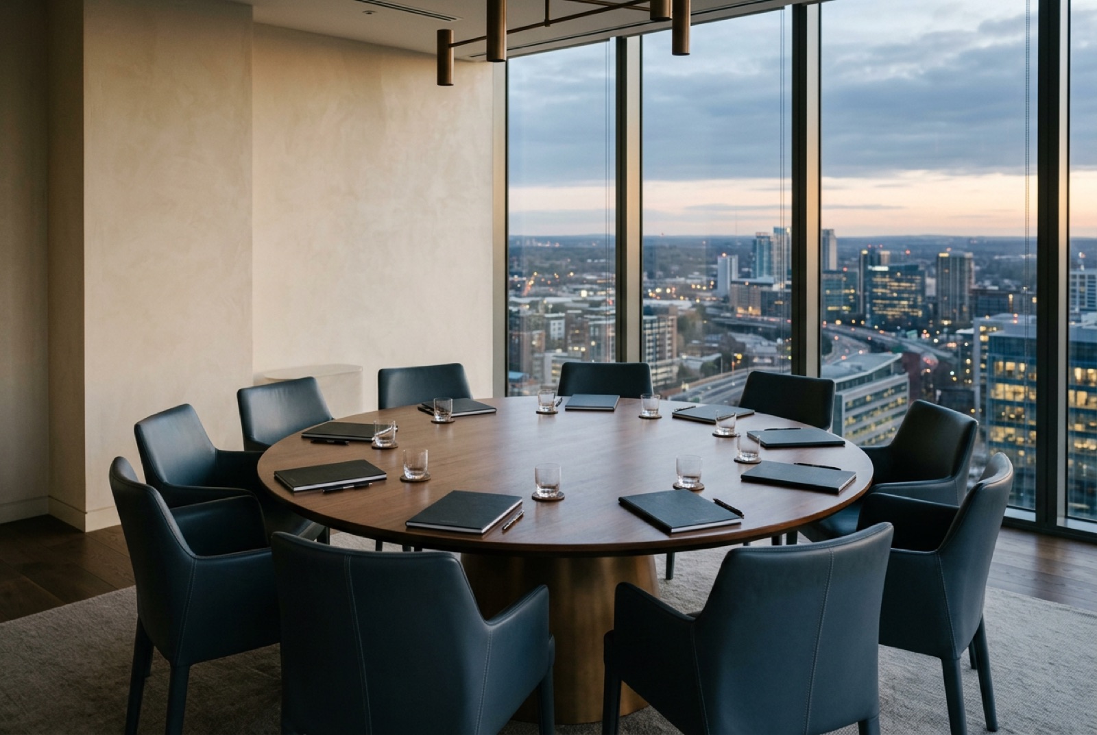 A round forum table with twelve leather chairs in a top-floor meeting room
