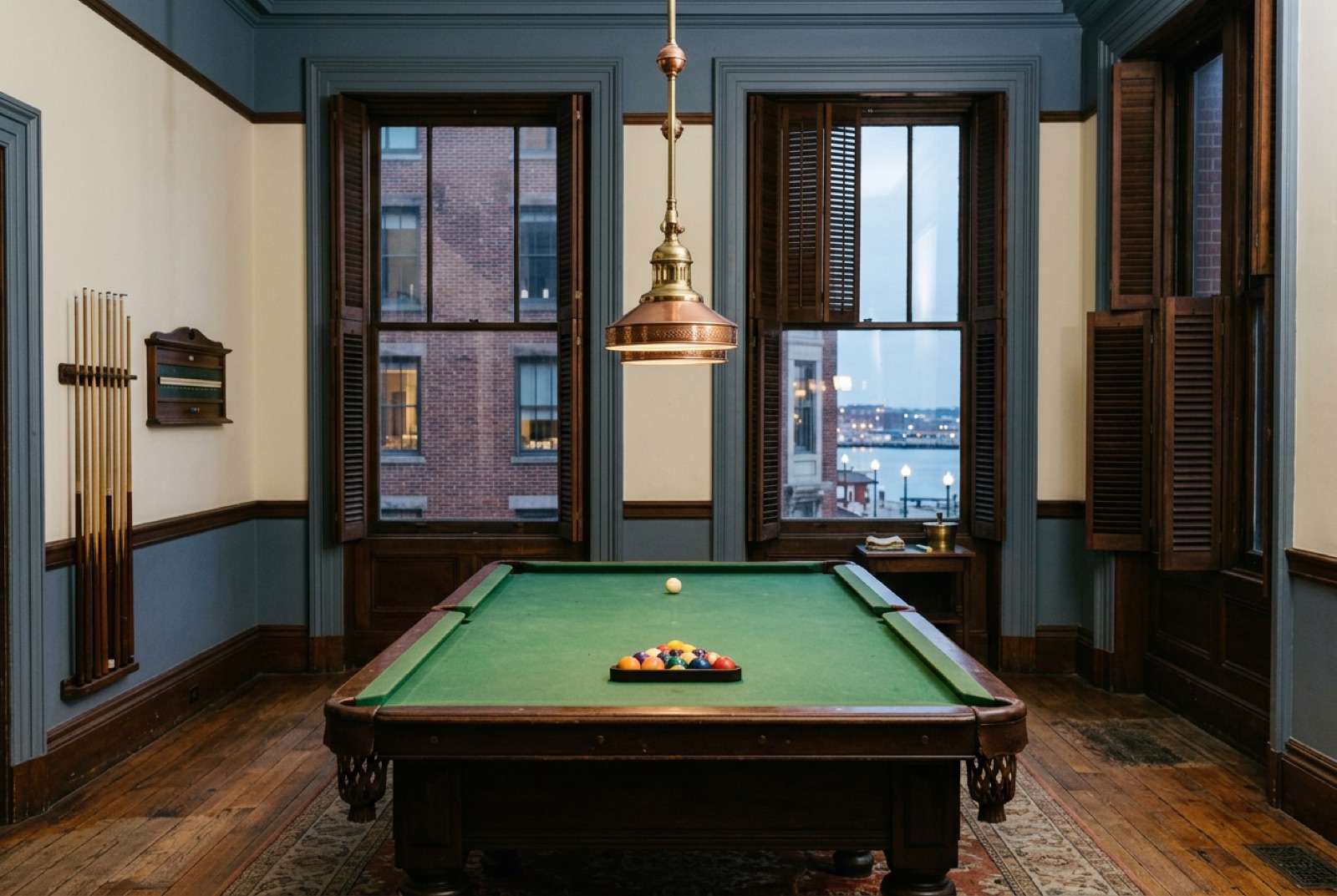 A billiard room with green baize and tall shuttered windows