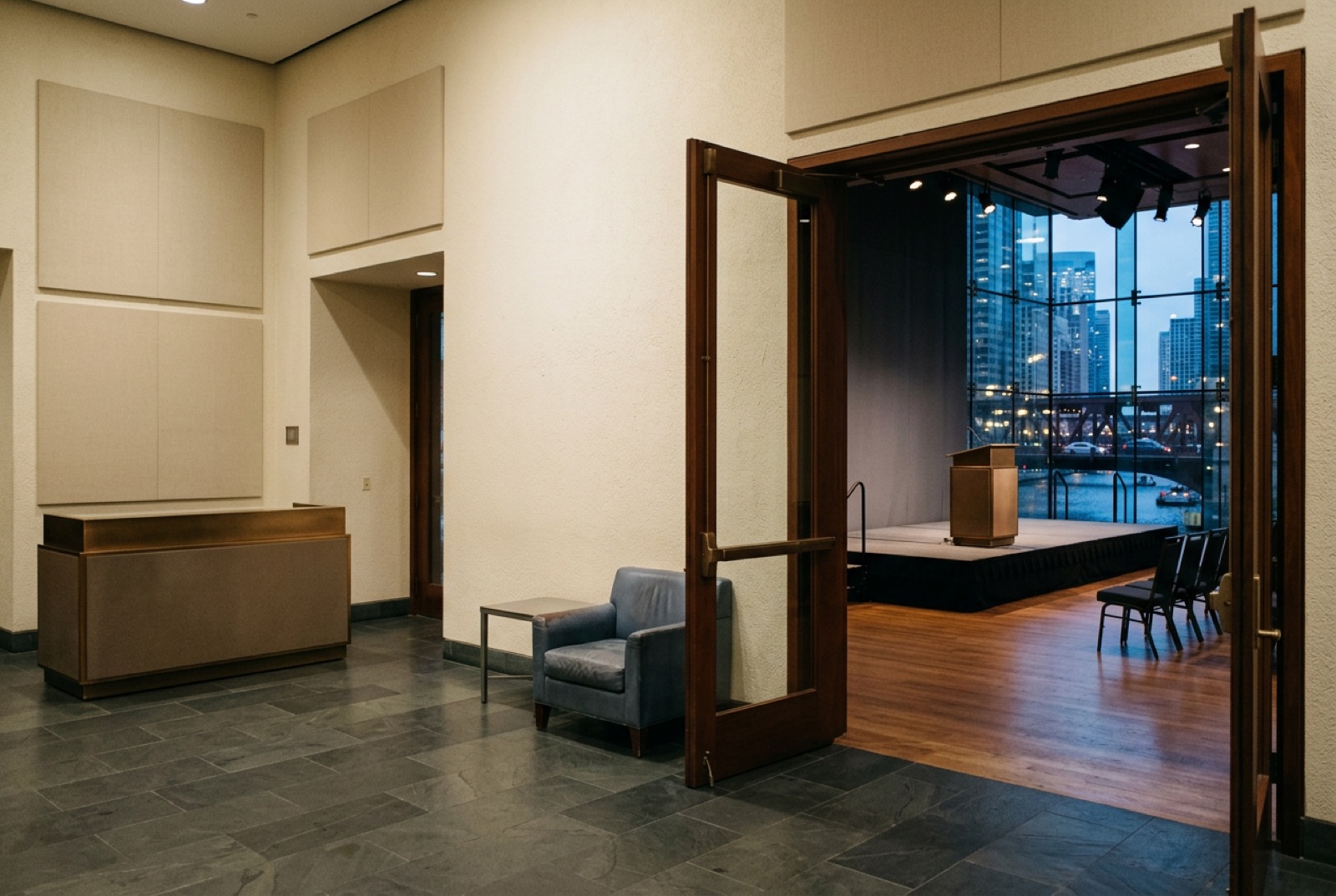 A conference foyer with a stage visible through open doors